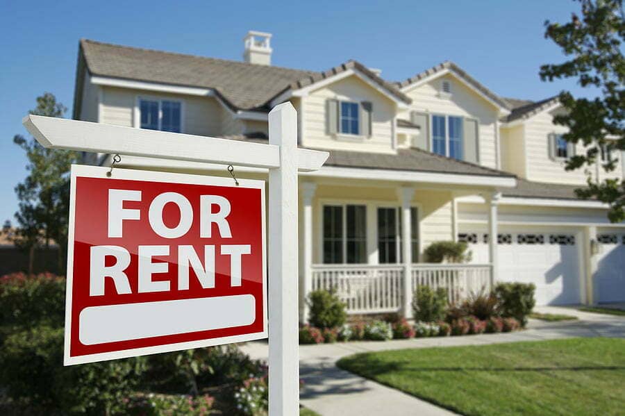 Right Facing Red For Rent Real Estate Sign in Front of Beautiful McCormack Realty Renters Choice Homes Long Term Property Management Kissimmee FL